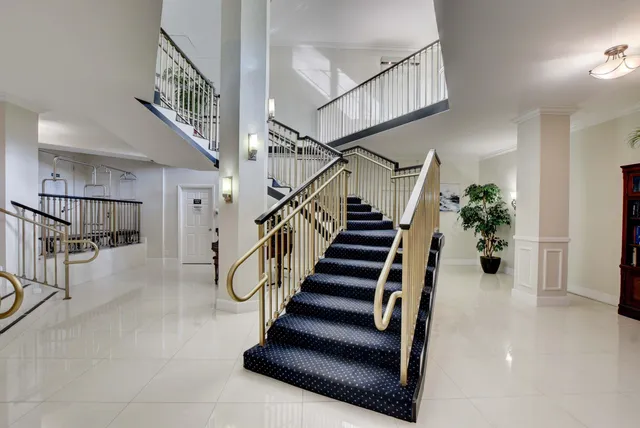 a living room with lots of white furniture and a large window