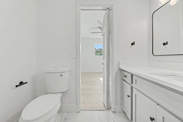 an empty room with wooden floor cabinet and windows