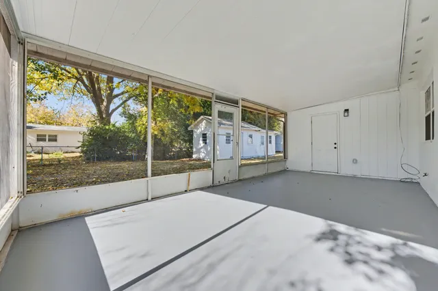 a backyard of a house with large trees and plants