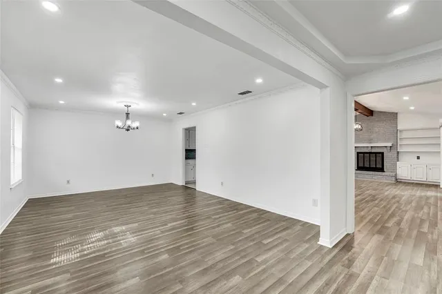 a view of a big room with wooden floor and a kitchen
