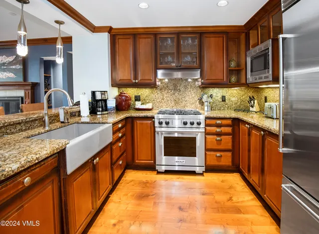 a kitchen with stainless steel appliances granite countertop a stove top oven sink and cabinets
