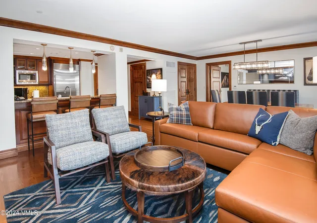 a living room with furniture a chandelier and a large window