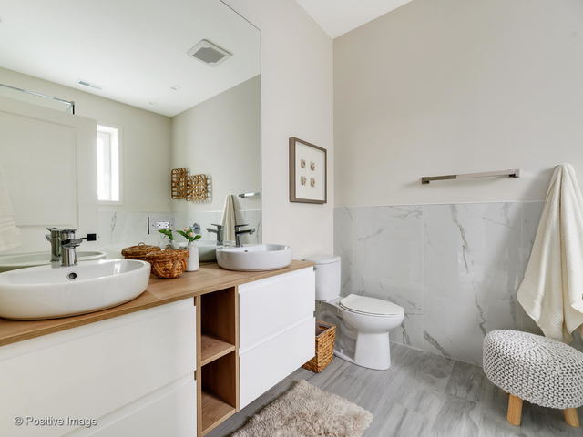 770 East Irving Park Road, Unit 3E Roselle, IL 60172 - Photo 10 of 17 a bathroom with a sink toilet and a mirror