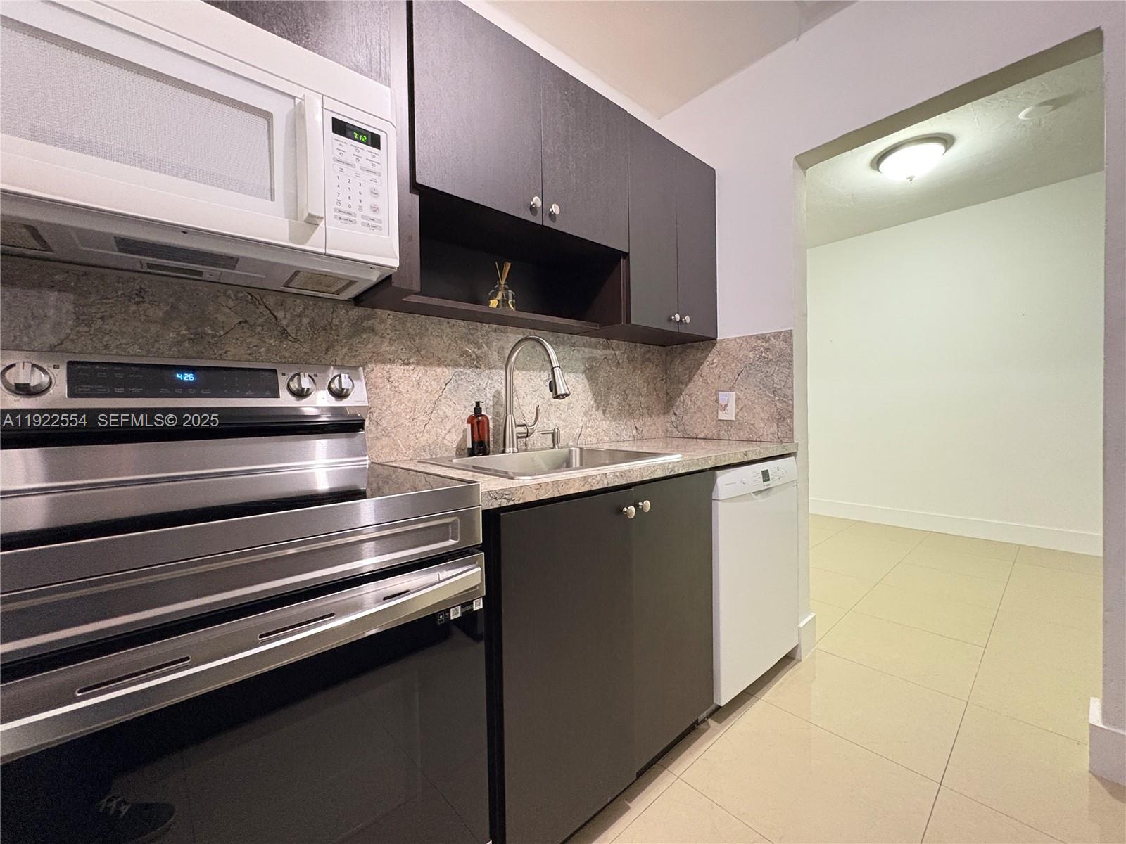 527 Southwest 9th Avenue, Unit 527 Miami, FL 33130 - Photo 13 of 34 a kitchen with stainless steel appliances a sink dishwasher a stove and a microwave oven