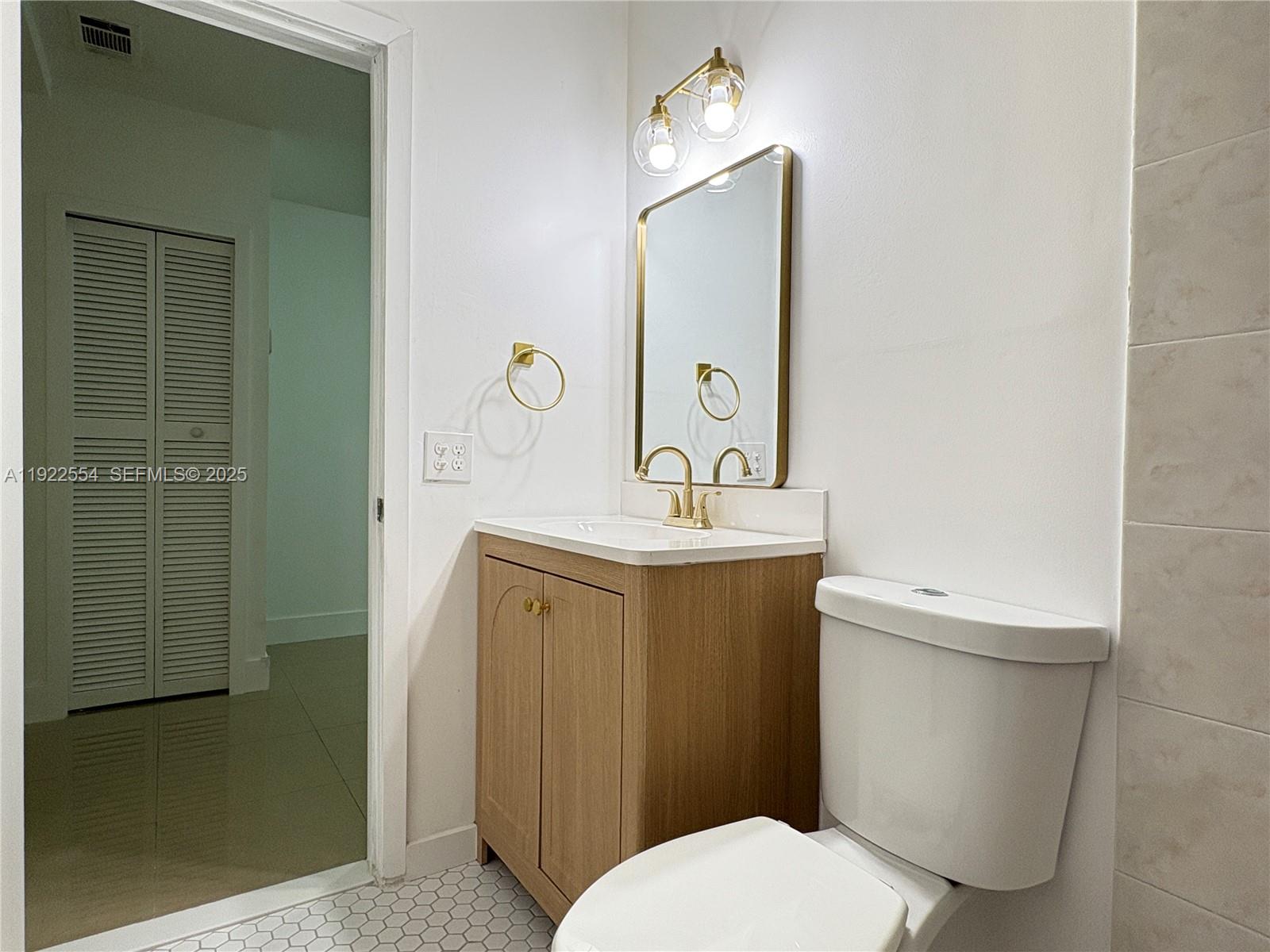 527 Southwest 9th Avenue, Unit 527 Miami, FL 33130 - Photo 16 of 34 a bathroom with a toilet a sink a mirror and vanity