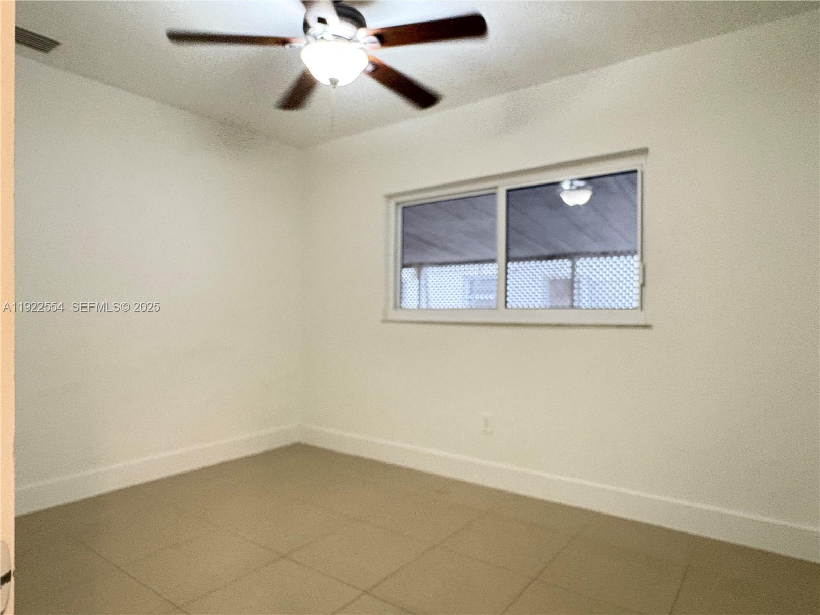 527 Southwest 9th Avenue, Unit 527 Miami, FL 33130 - Photo 28 of 34 an empty room with a window and ceiling fan