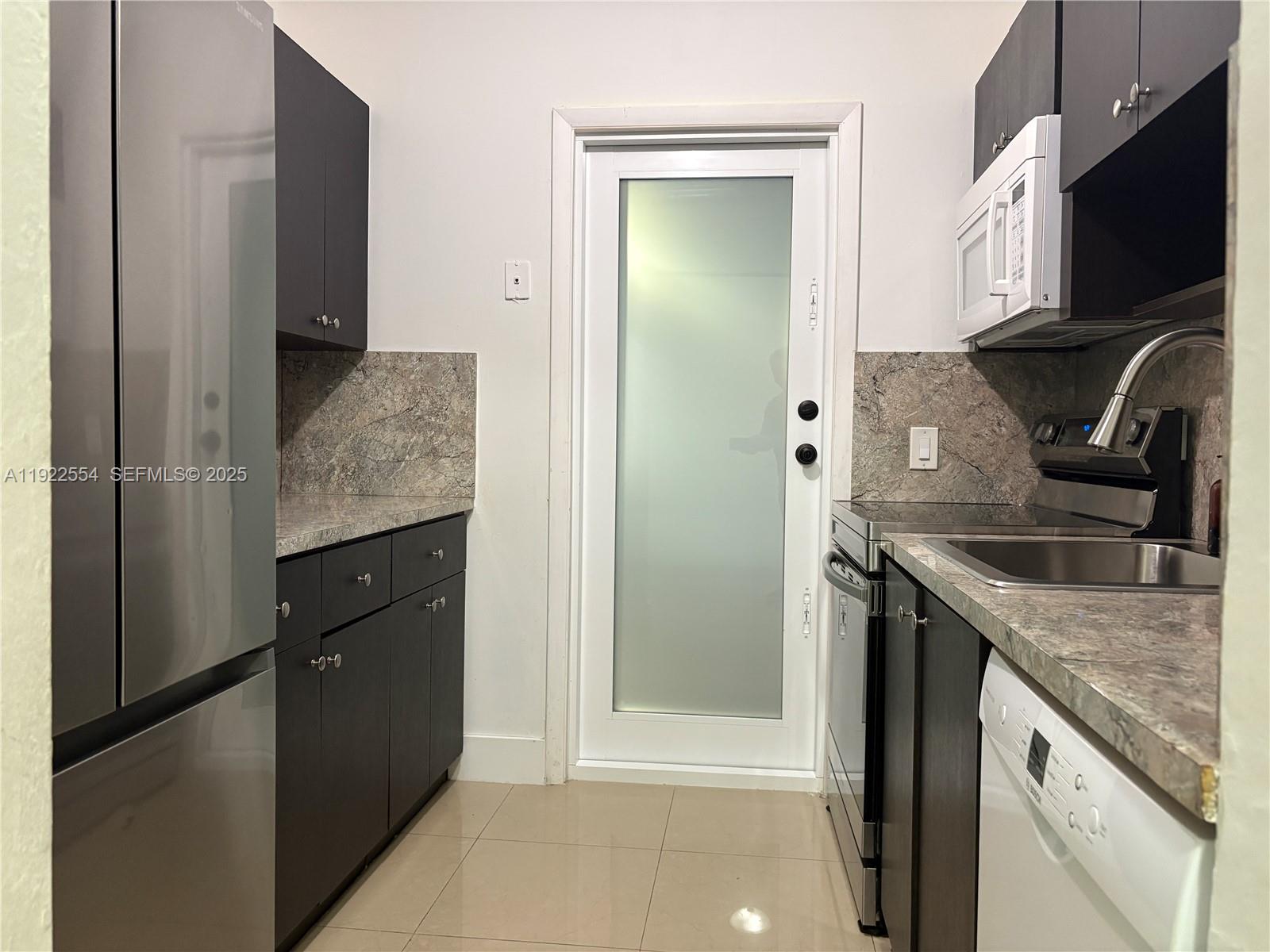 527 Southwest 9th Avenue, Unit 527 Miami, FL 33130 - Photo 10 of 34 a kitchen with stainless steel appliances granite countertop a refrigerator and a sink