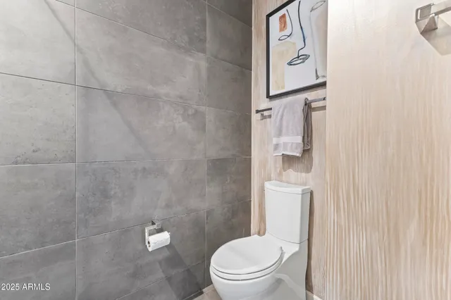 a view of a terrace with lawn chairs and a barbeque