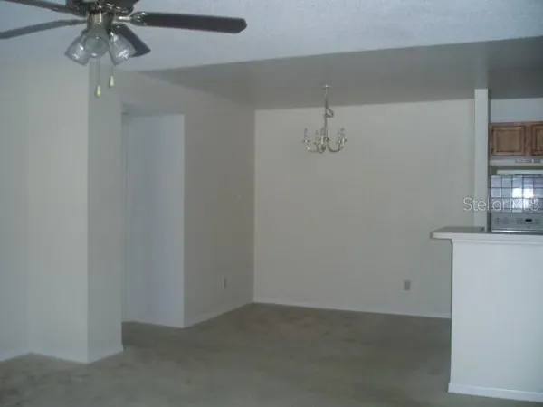 an empty room with a chandelier fan