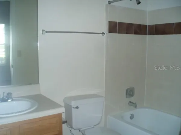 a bathroom with a granite countertop sink a toilet and shower