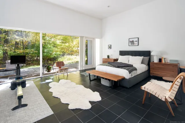 a bedroom with a bed and large windows