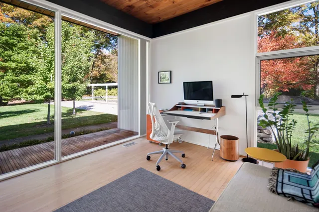 a living room with a floor to ceiling window and a table