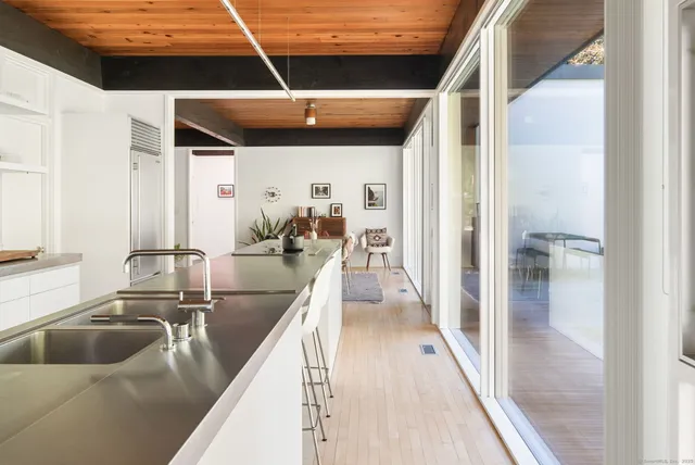 a kitchen with a sink dishwasher and a refrigerator with wooden floor