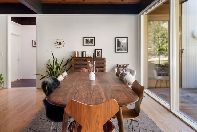a view of a dining room with furniture and a potted plant