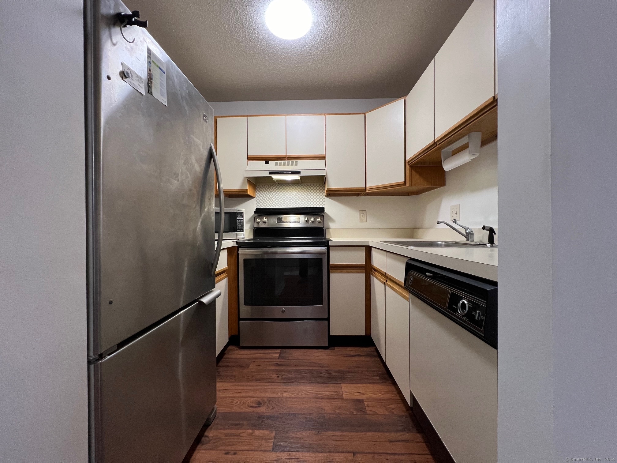 35 Ruth Street, Unit 66 Bristol, CT 06010 - Photo 5 of 17 a kitchen with stainless steel appliances granite countertop a stove a refrigerator and a sink
