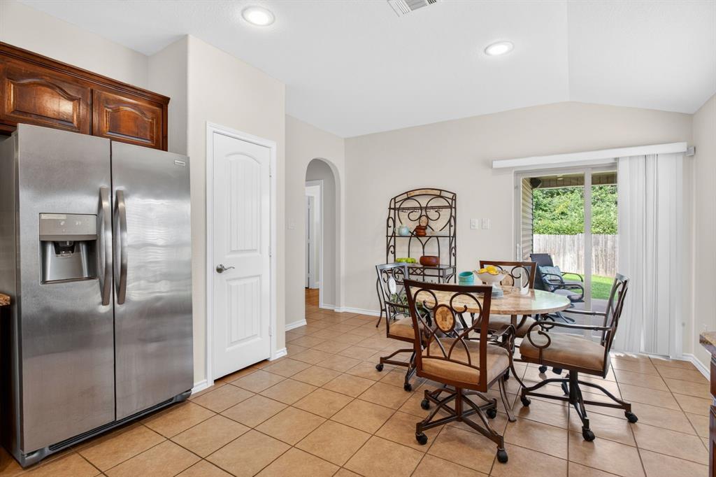5069 Britton Ridge Lane Fort Worth, TX 76179 - Photo 13 of 32 Stainless steel fridge conveys. Pantry, dining area, and a hallway leading to the primary suite.