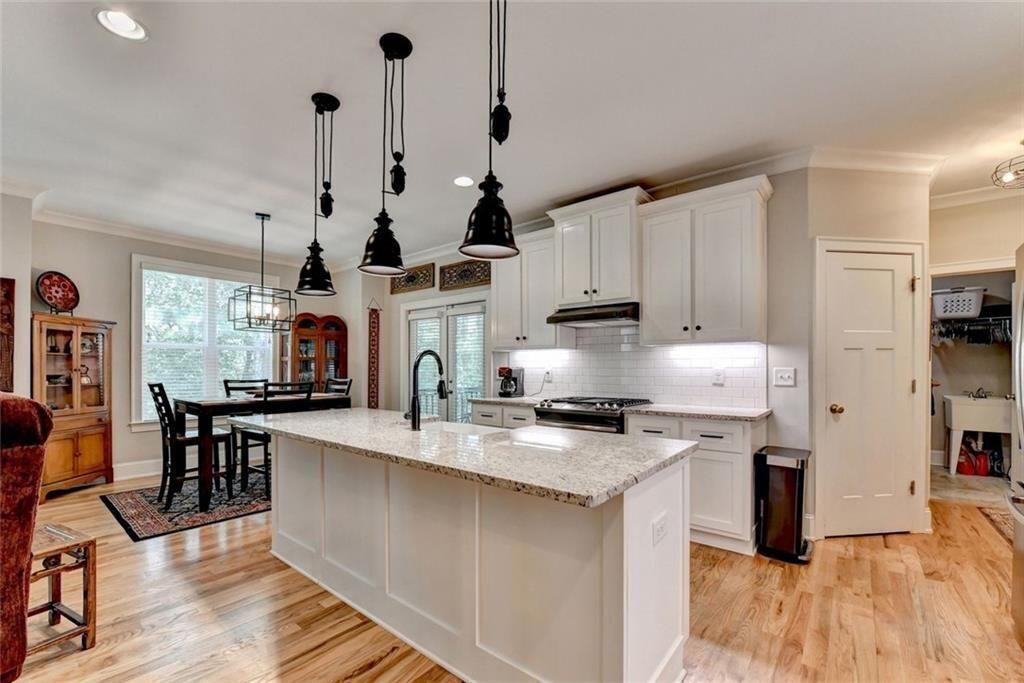 919 Fields Chapel Road Canton, GA 30114 - Photo 17 of 58 a kitchen with stainless steel appliances granite countertop a stove a sink a refrigerator and white cabinets with wooden floor