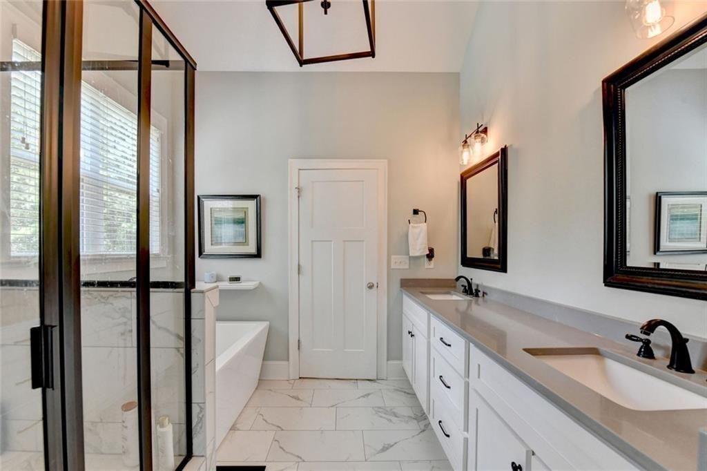 919 Fields Chapel Road Canton, GA 30114 - Photo 31 of 58 a spacious bathroom with a double vanity sink a mirror a bathtub and next to a window
