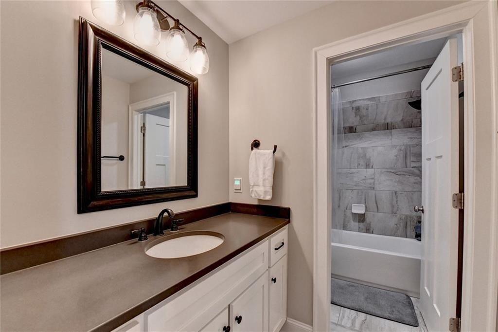 919 Fields Chapel Road Canton, GA 30114 - Photo 36 of 58 a bathroom with a granite countertop sink a mirror and a shower