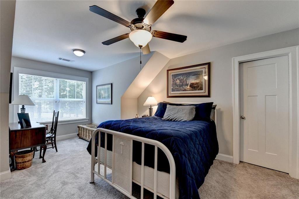 919 Fields Chapel Road Canton, GA 30114 - Photo 38 of 58 a bedroom with a bed a desk and chair with a large window