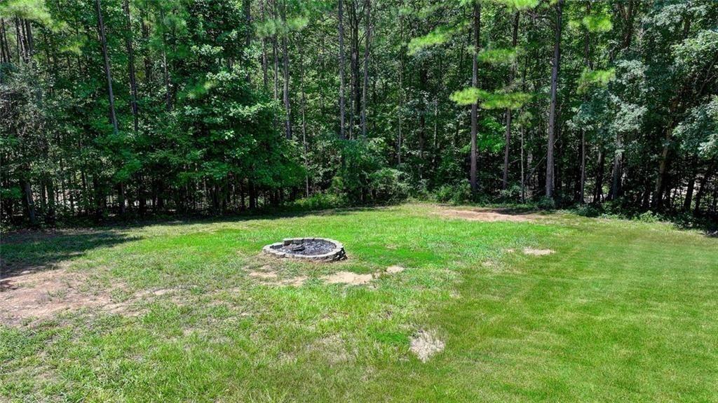 919 Fields Chapel Road Canton, GA 30114 - Photo 57 of 58 a view of a backyard with table and chairs a fire pit