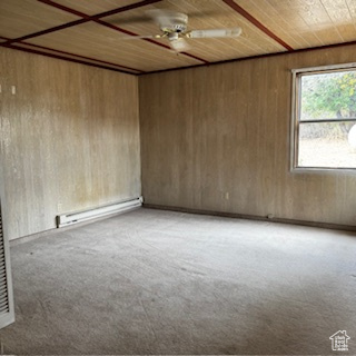 4709 East Independence Road Myton, UT 84052 - Photo 15 of 27 Unfurnished room featuring light carpet, a baseboard radiator, ceiling fan, wooden walls, and wooden ceiling