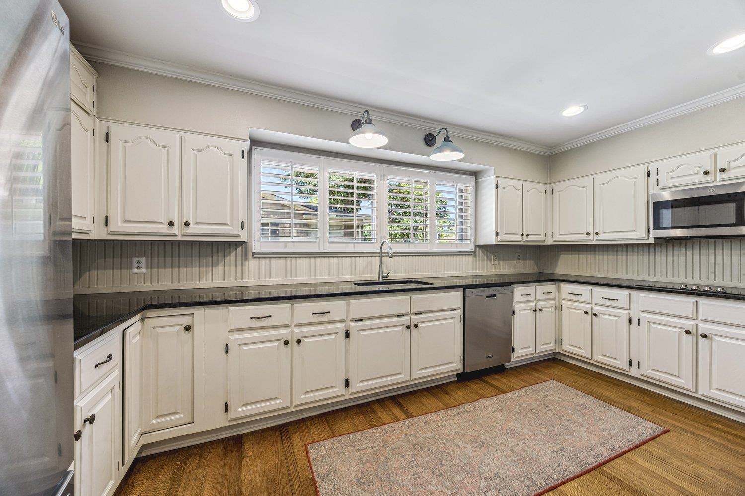 4220 Minden Road Memphis, TN 38117 - Photo 10 of 30 a kitchen with granite countertop white cabinets and white appliances