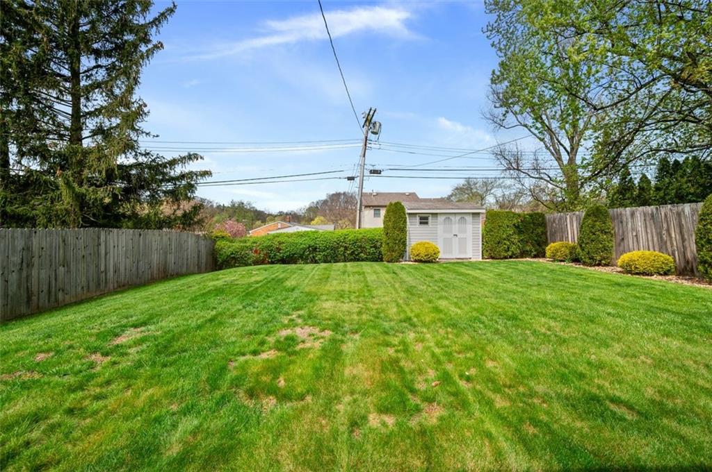 172 Eileen Drive Pittsburgh, PA 15227 - Photo 21 of 21 a yellow house with flower garden in front of it
