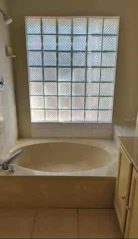 a bathroom with a bathtub and next to a window