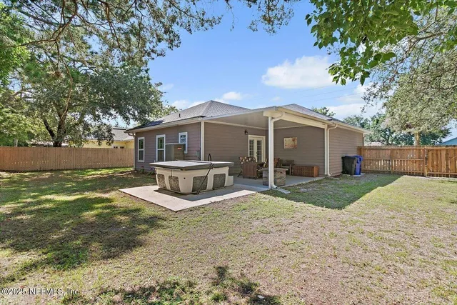 a view of a house with backyard and trees