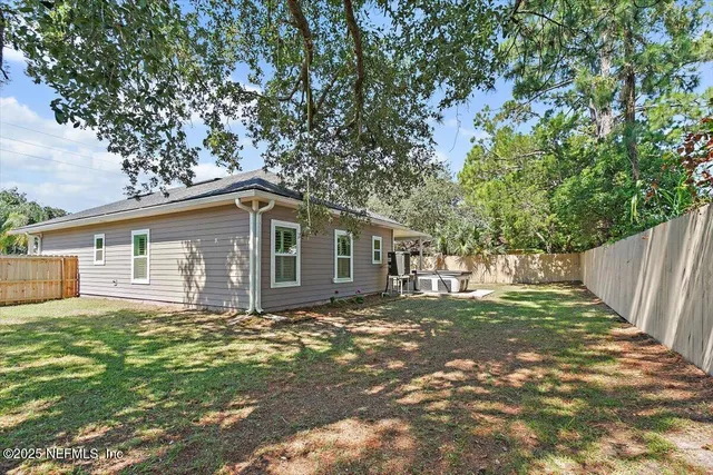 a backyard of a house with large trees and brick walls