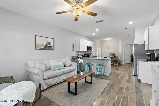 a living room with furniture and kitchen view