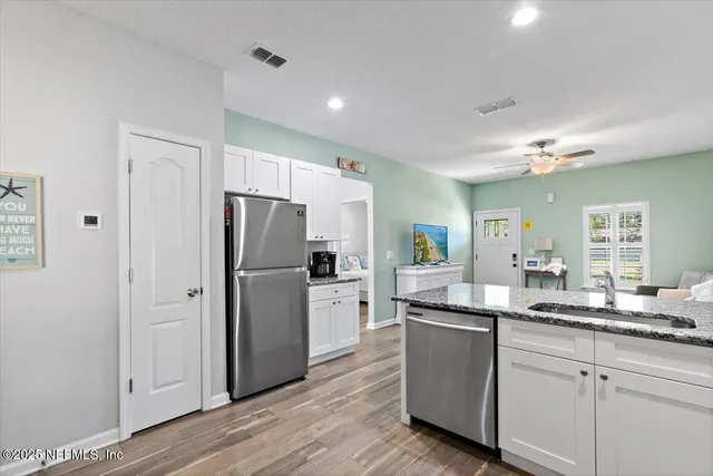 a kitchen with white cabinets and stainless steel appliances