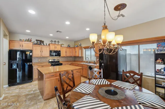 a kitchen with a stove a sink a counter top space and living room view