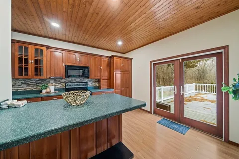 a view of kitchen island a sink wooden floor and a counter top space
