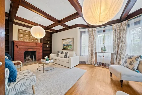 a living room with furniture a fireplace and a large window