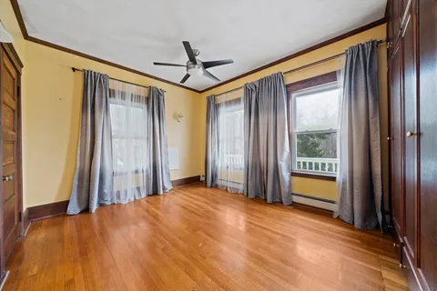 a view of a room with wooden floor and windows