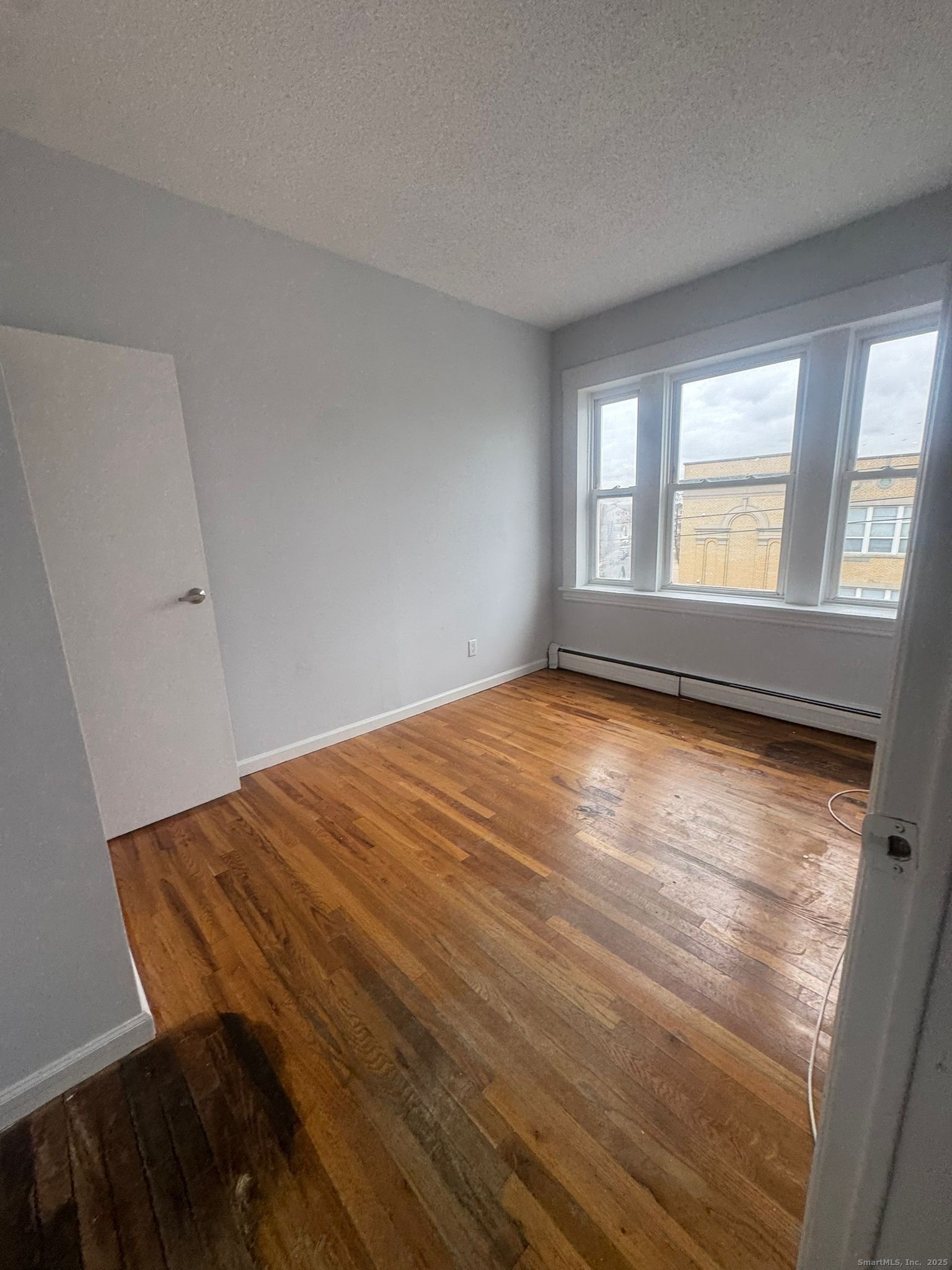 335 Wells Street, Unit W24 Bridgeport, CT 06606 - Photo 3 of 4 a view of empty room with wooden floor and fan