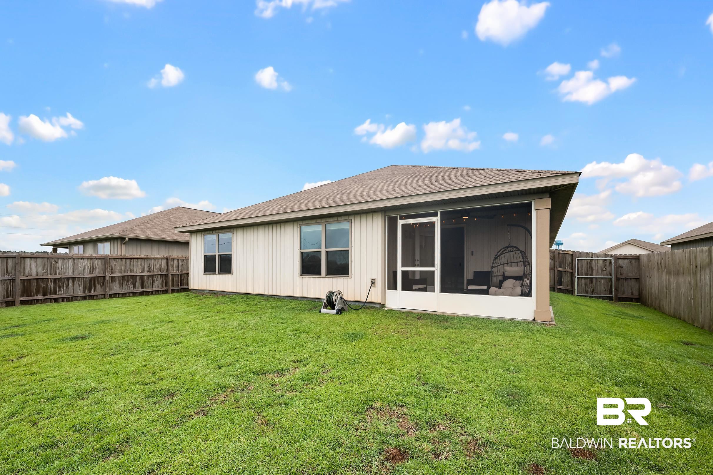 32030 Terranova Loop Lillian, AL 36549 - Photo 20 of 30 Expansive rear lawn featuring a privacy fence and a screened-in patio