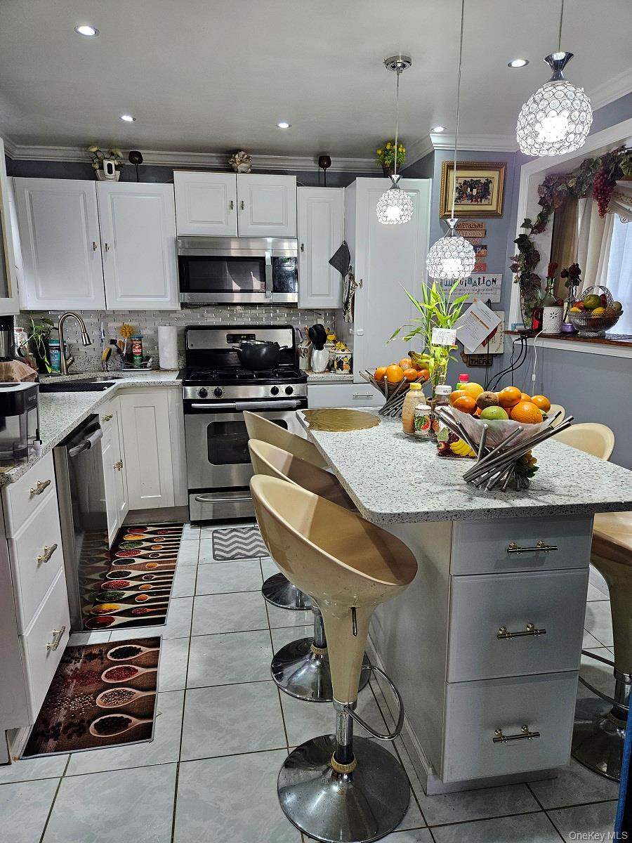 111-31 140th Street Queens, NY 11435 - Photo 6 of 20 a kitchen with kitchen island granite countertop a sink cabinets and stainless steel appliances