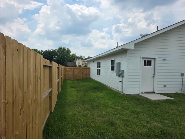a view of a backyard with wooden fence