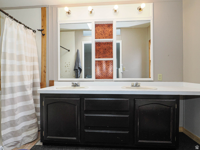 94 Spring Canyon Road Coalville, UT 84017 - Photo 44 of 50 Dual vanity with solid surface countertop, integrated sinks, and black cabinetry