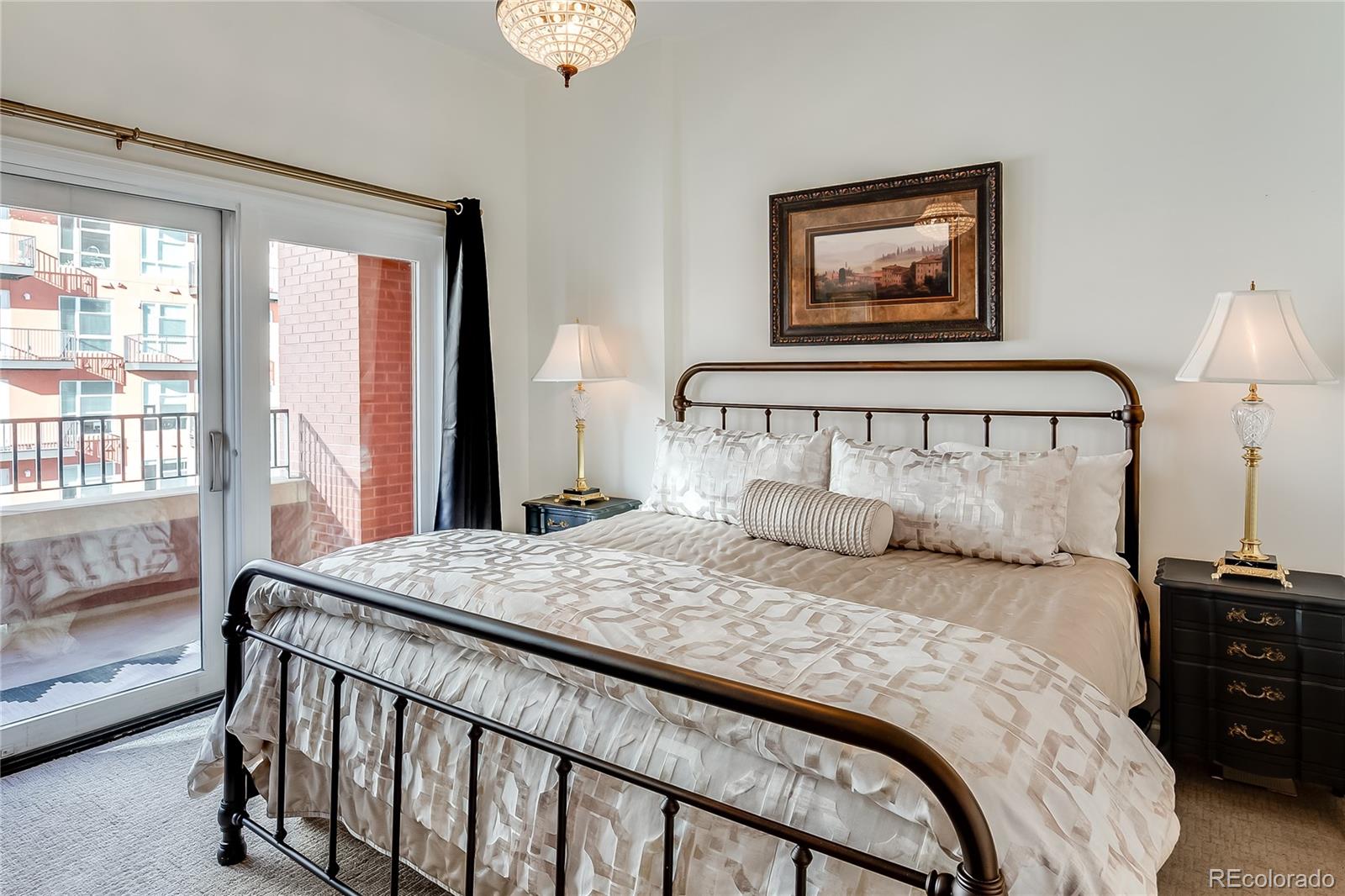 1950 Logan Street, Unit 814 Denver, CO 80203 - Photo 9 of 16 a bedroom with a bed a couch and a window