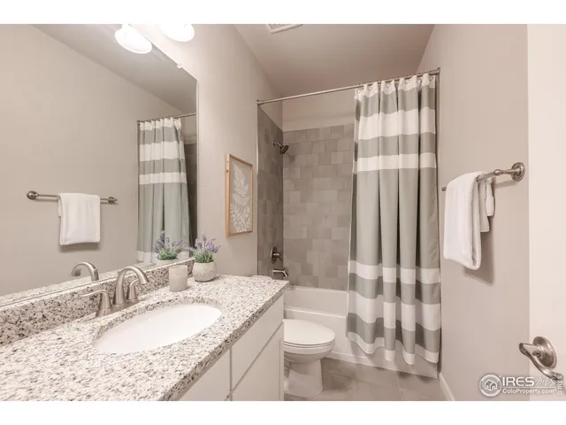 a bathroom with a granite countertop sink a mirror and a shower