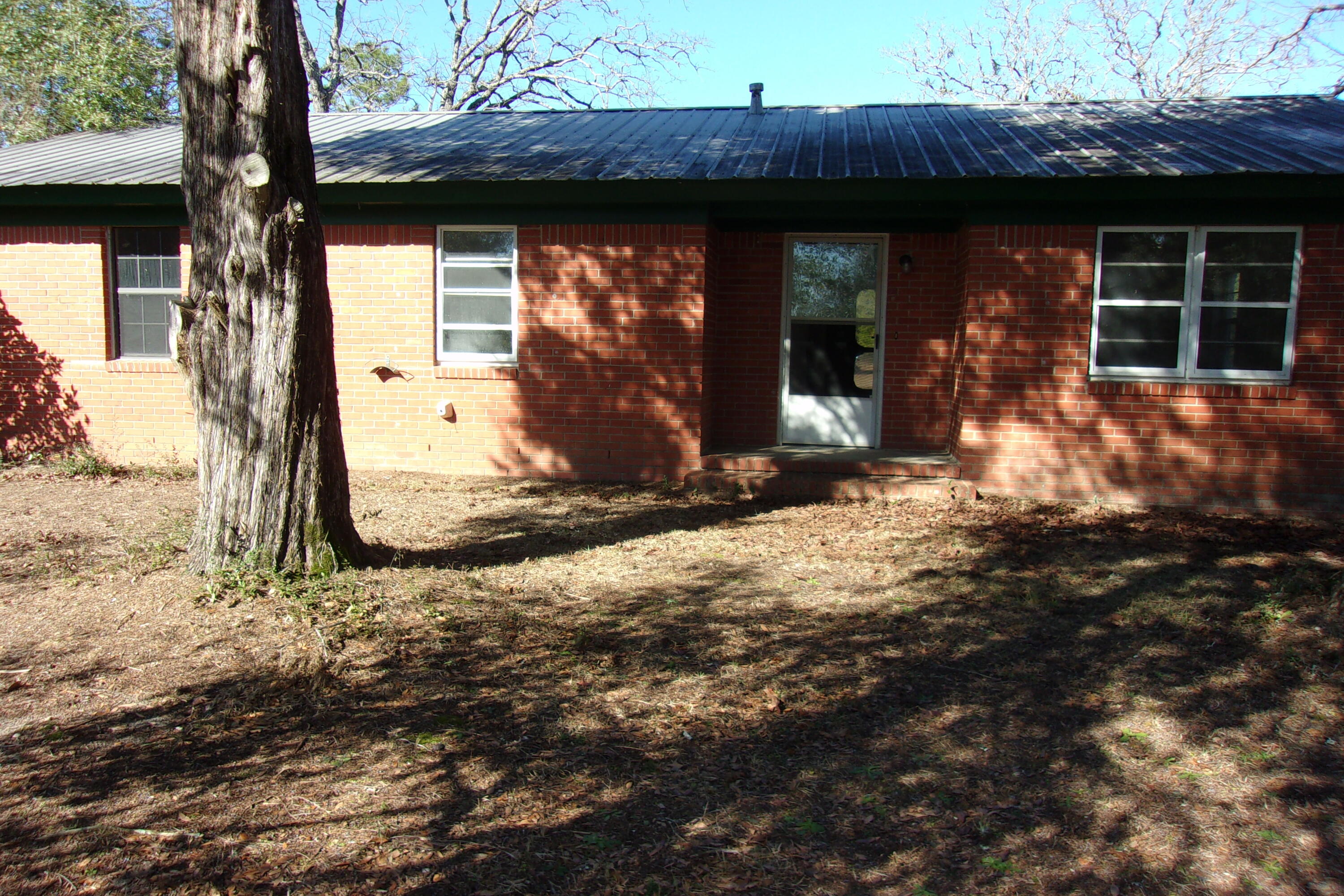 4071 Painter Branch Road Crestview, FL 32539 - Photo 8 of 64 a view of a house with a large tree and wooden fence