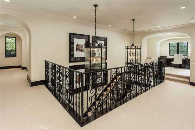 a view of staircase with railing and a chandelier