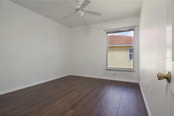 an empty room with a window and wooden floor