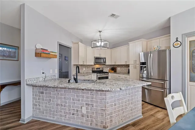 a kitchen with granite countertop cabinets stainless steel appliances a sink and a large window