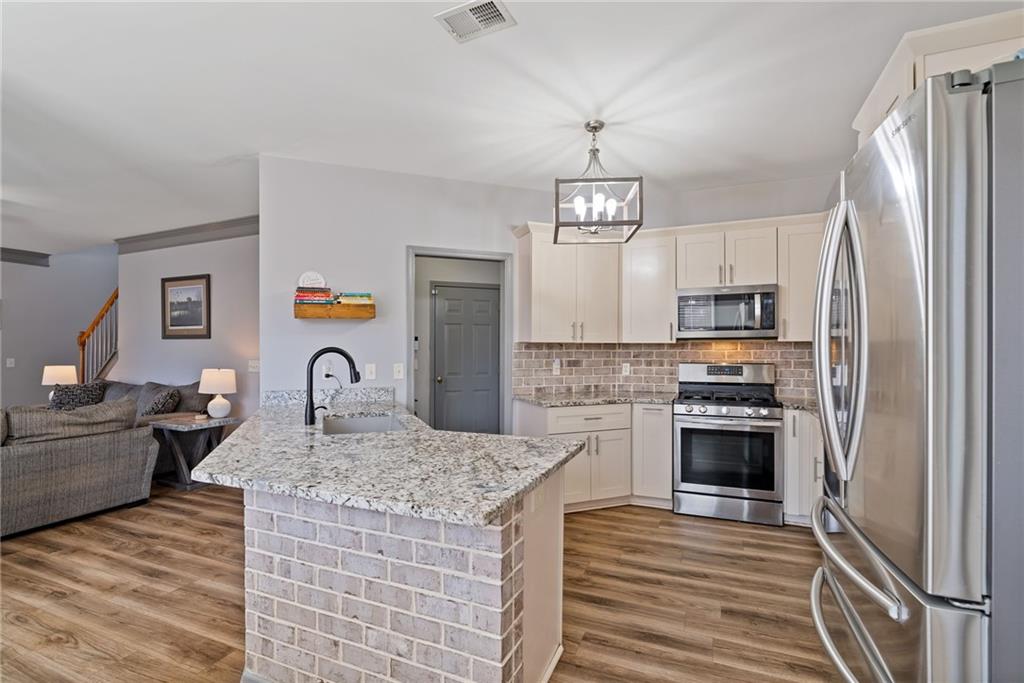232 Springs Crossing Canton, GA 30114 - Photo 22 of 57 a kitchen with stainless steel appliances granite countertop a stove refrigerator and cabinets