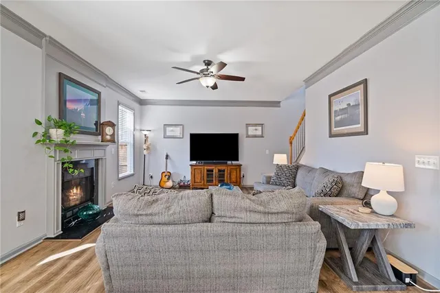 a living room with couches and kitchen view with wooden floor